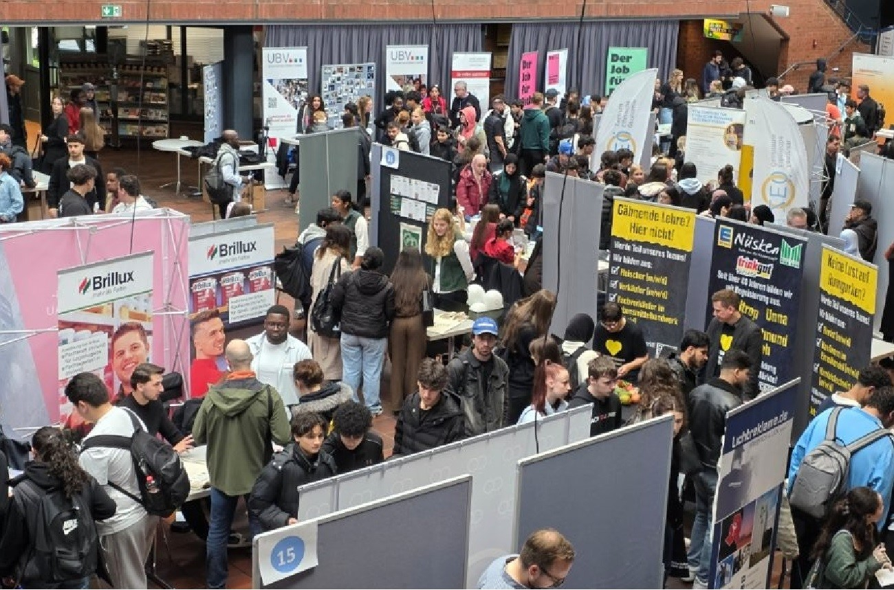 Schülerinnen und Schüler informieren sich auf der Ausbildungsmesse ‚Deine Zukunft – Nach der Schule!‘ an verschiedenen Messeständen.